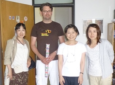 Auf dem Foto sind Herr Prof. Denis Köhler und drei Kollegen aus Japan abgebildet. Prof. Köhler hält ein Geschenk in der Hand.
