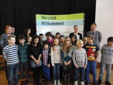 Das Foto zeigt die Kinder der Thomas-Schule bei der Preisverleihung am Montag, dem 2.3.; rechts der Schulleiter Herr Eich, neben dem Schuldezernenten der Stadt Düsseldorf, Herrn Hintzsche, links Christina Muscutt, wiss. Mitarbeiterin der Forschungsstelle FSPE und Carina Bhatti, einer Studentin, die im ersten Projekt mitgearbeitet hat